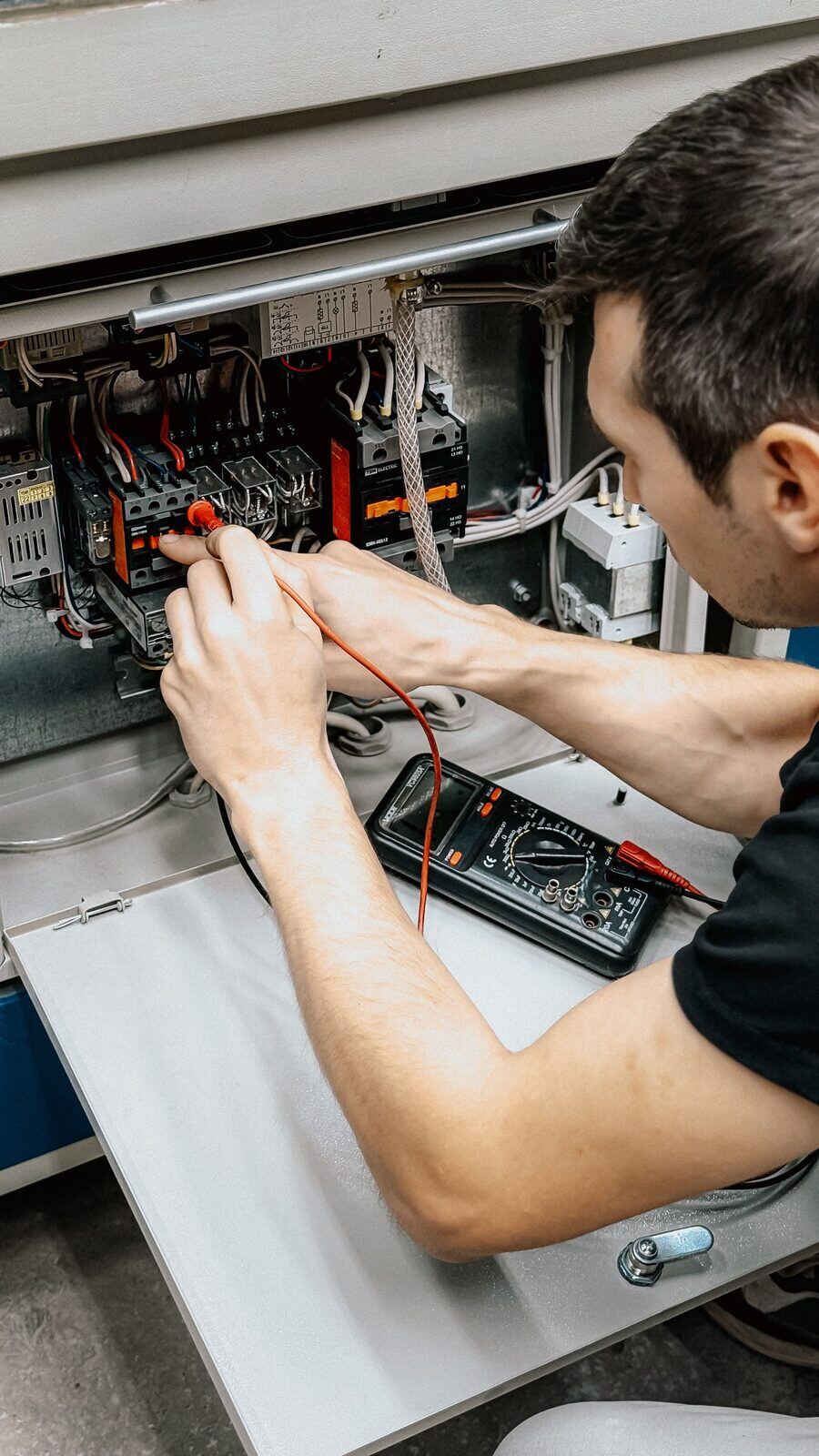 Electricista diagnosticando un tablero eléctrico con multímetro